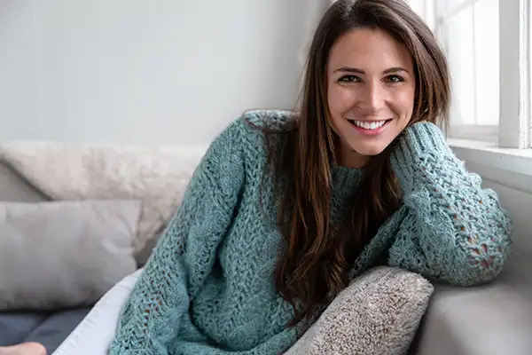 Smiling woman sitting on sofa